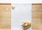 Huge natural seashell on a white towel on a wooden background and a small white stone