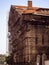 A huge old building under reconstruction, restoration or rebuilding, surrounded by scaffolding.