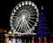 Huge outdoor illuminated Christmas tree with ferris wheel in background in Bournemouth, Dorset, UK