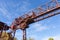 Huge overhead trolley structure, rusted metal industrial architecture against a blue sky