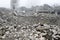 A huge pile of gray concrete debris from piles and stones of the destroyed building. The impact of the destruction