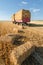 Huge pile of hay on trailer standing on agricultural field