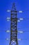 Huge Pylon of the high-voltage power line against the blue sky.