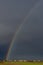 Huge rainbow over the Tuscan countryside against a dark cloudy sky