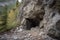 huge rock slide, blocking entrance to mountain cave, with dust and debris still settling