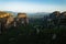 Huge rocks with christian orthodox monasteries at sunrise with Meteora valley in background near Kalambaka, Thessaly