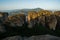 Huge rocks with christian orthodox monasteries at sunrise with Meteora valley in background near Kalambaka, Thessaly