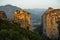 Huge rocks with christian orthodox monasteries at sunrise with Meteora valley in background near Kalambaka, Thessaly