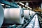 Huge rolls of paper are stored in the factory warehouse. Industrial paper production. Finished products of a paper processing
