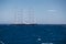 A huge sail yacht of conceptual design with three masts stands in the bay near Monaco at sunny day, the sails are