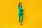 Huge sale, ad and offer. Happy trendy lady standing and pointing fingers at free space, yellow background, full length