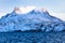 Huge Sermitsiaq mountain covered in snow with blue sea and small