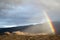 Huge sky full of clouds with tiny rainbow over the Santa Catalina mountains in Tucson, Arizona