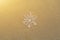 Huge sparkling snowflake on the sand in the sea foam. Concept of Winter and Christmas vacation on the beach