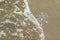 Huge sparkling snowflake on the sand in the sea foam. Concept of Winter and Christmas vacation on the beach and resort.