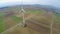 Huge spinning blades of wind turbine in countryside, aerial. Power generation