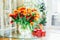 Huge spring bouquet of tulips in vase and gift box on the table with light classic interior design background. Gift for holiday,