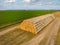 Huge storage stack of straw bales collected by modern tractor