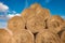 Huge straw pile of Hay roll bales on among harvested field. cattle bedding