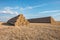 Huge straw pile of Hay roll bales on among harvested field. cattle bedding