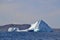 Huge sunlit icebergs in bay outside St. John\\\'s with Cabot Tower on the horizon