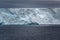 Huge table iceberg, tabular iceberg, with wall and texture in dark rough Southern Ocean, Antarctica