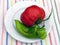 Huge tomato and atypically grown green pepper on white plate