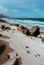 Huge volcanic stone boulder on spectacular white sand dunes of remote deserted beach Praia Grande. Ocean hitting