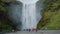 Huge waterfall of Skogafoss with tourists visiting, Skogar, south of Iceland