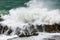 Huge wave crashing rocky coastline in Hermanus