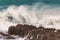 Huge wave crashing rocky coastline in Hermanus, South Africa