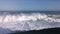 Huge waves crashing against the rocks and releasing large amounts of white foam