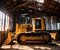 Huge yellow bulldozer in an abandoned barn