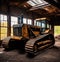 Huge yellow bulldozer in an abandoned barn