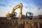 huge yellow crawler excavator and a construction dump truck