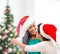 Hugging mother and daughter in santa helper hats