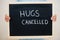Hugs cancelled. Coronavirus concept. Boy hold inscription on the board