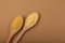 Hulled millet flour and grain in wooden spoon, top view. Beige brown background, space for your text