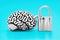 Human brain linked with a padlock isolated on blue