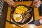 Human eating sizzling beef sisig rice on iron platter