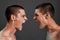 Human emotions. Close up of two young angry caucasian twin brothers arguing, shouting while standing face to face