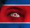 Human face painted North Korea flag with red star within a white circle on the center of eye or eyeball