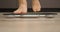 Human feet are standing on scales, close up. Woman on scales measuring weight. Weight loss concept