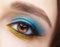 Human female eye with blue smoky eyes shadows and yellow liner