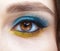 Human female eye with blue smoky eyes shadows and yellow liner