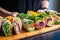 human fingers arranging colorful vegan wraps on a wooden tray