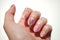 Human fingers with beautiful floral manicure. Nail art with cute painted flowers. White background