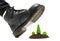 Human foot wearing a work boot steps on a miniature forest made of soil and toy plastic trees. A large humanity`s ecological foot