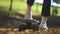 Human foot in white sneakers on a skateboard close-up. Foot in a white sneaker raises a skateboard on the background of