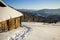 Human footprint path in white deep snow leading to small old wooden forsaken shepherd hut in mountain valley, spruce forest, woody